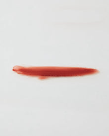 Red ip gloss swatch on a white background