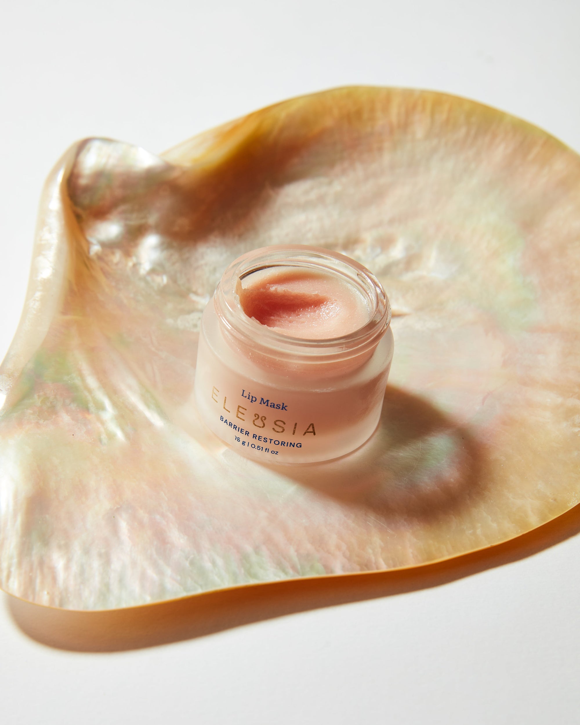 Lip mask jar on a decorative shell with 'ELEUSIA' branding