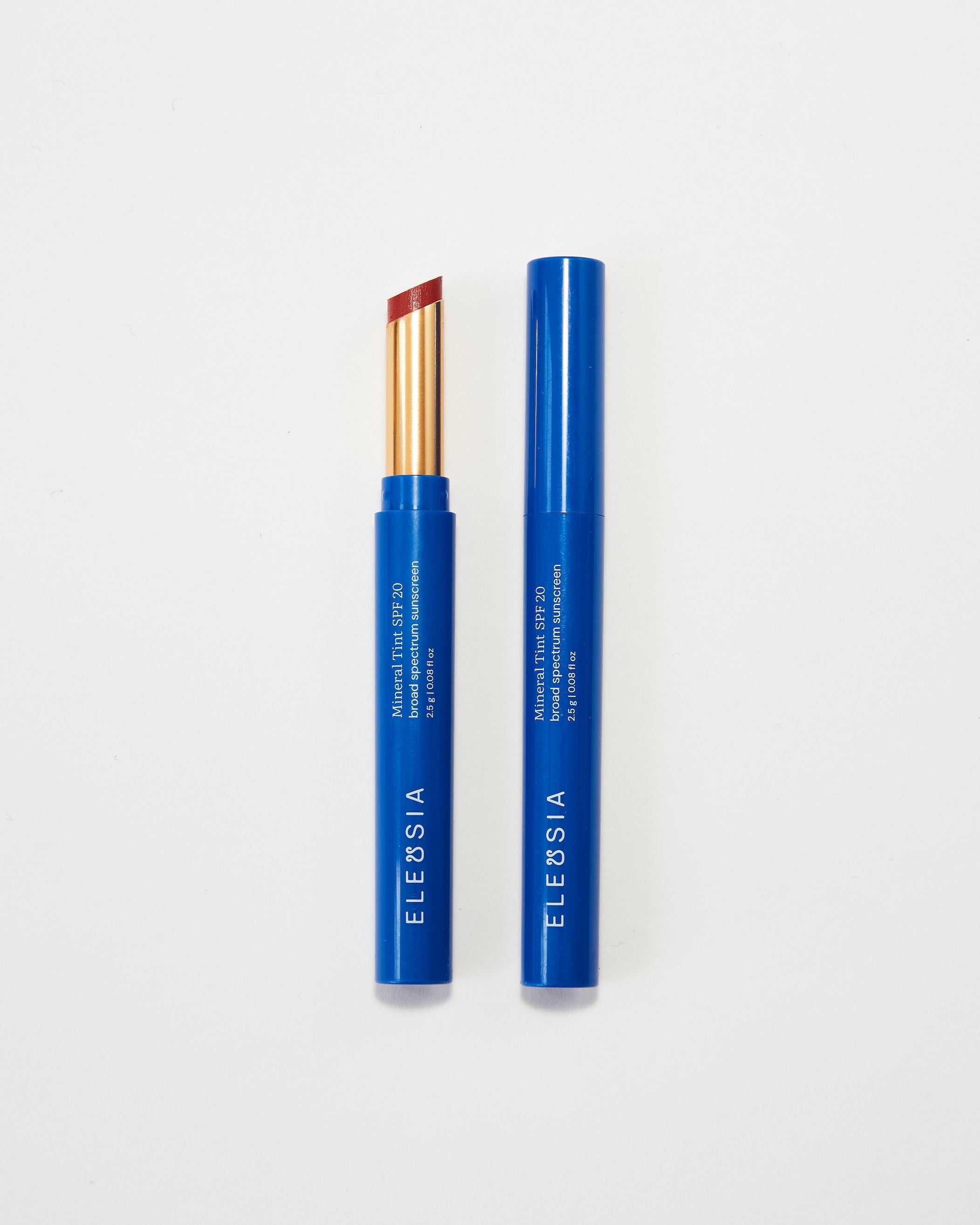 Two blue lip products with gold accents on a white background, featuring the brand 'ELEUSIA'.